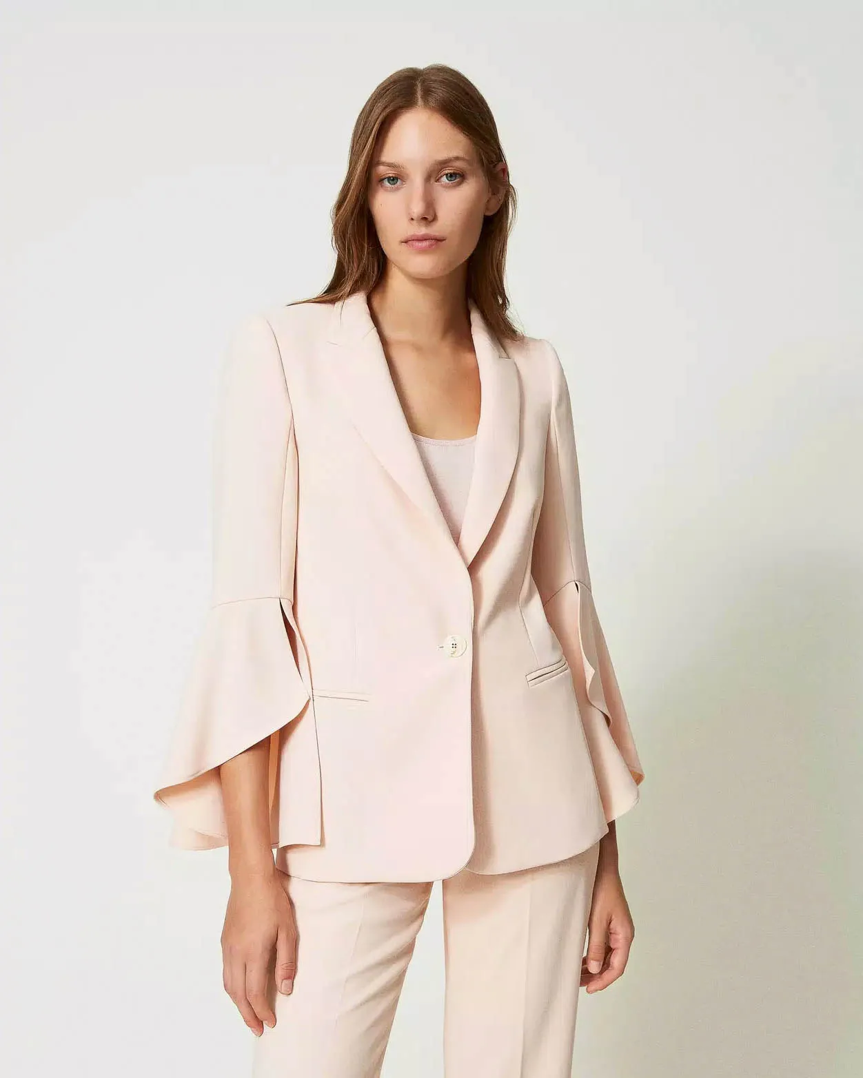 Tailleur rosa in cady con pantaloni palazzo e maniche a campana della giacca a un bottone